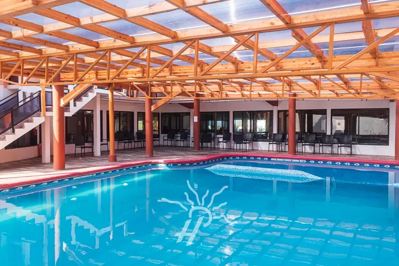 Alberca techada y climatizada bajo estructura de madera · Hotel Coral